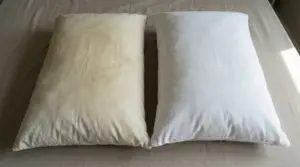 Due cuscini su un letto, uno visibilmente ingiallito e l'altro bianco e pulito