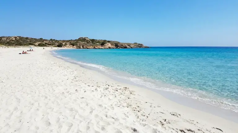 Spiaggia con sabbia bianca e mare cristallino in una baia tranquilla